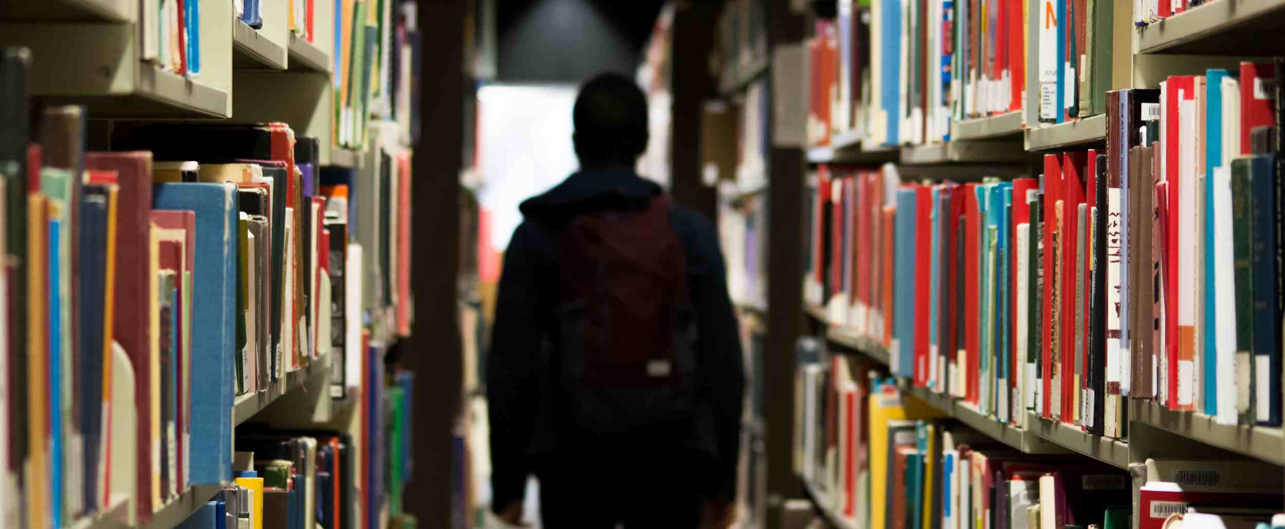 Persona de espaldas en una biblioteca