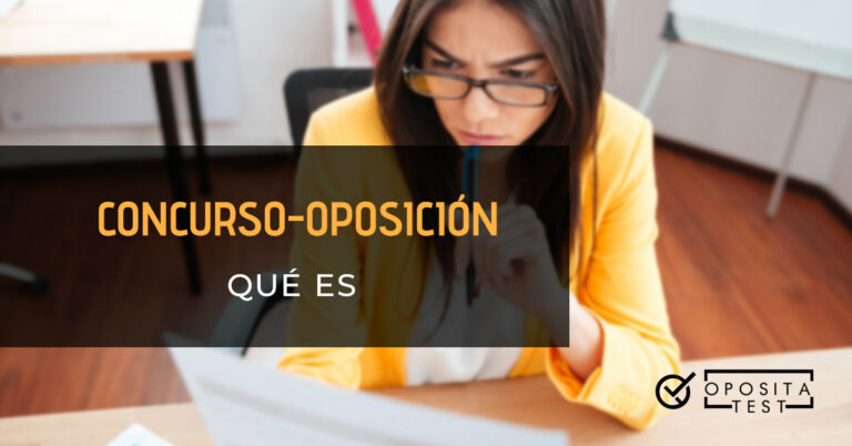 Mujer vestida con una chaqueta amarilla, camisa blanca y gafas sosteniendo un papel con una mano y apoyando un bolígrafo que sostiene con la otra en la barbilla. Toda la imagen está fuera de foco. Se utiliza para ilustrar una entrada sobre qué es un concurso-oposición.