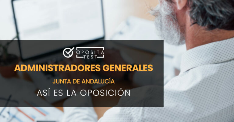 Hombre de espaldas tecleando en un portátil que se encuentra encima de una mesa sobre la que también hay otros papeles. Toda la imagen está fuera de foco. Se utiliza para ilustrar una entrada sobre la oposición de Administradores Generales de la Junta de Andalucía.