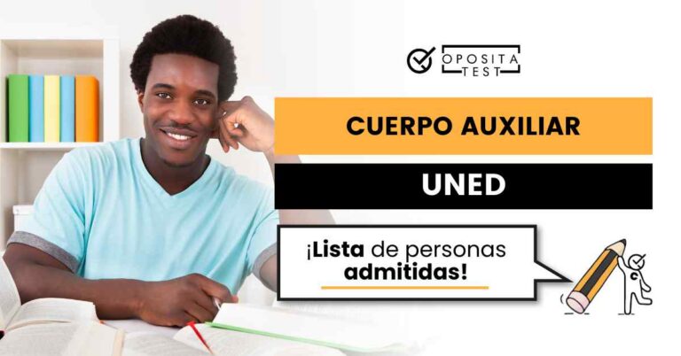 Hombre sonriente sentado en escritorio rodeado de libros